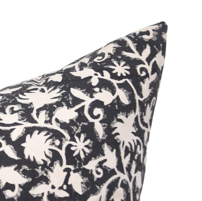Decorative pillow with black and white floral pattern on a white background