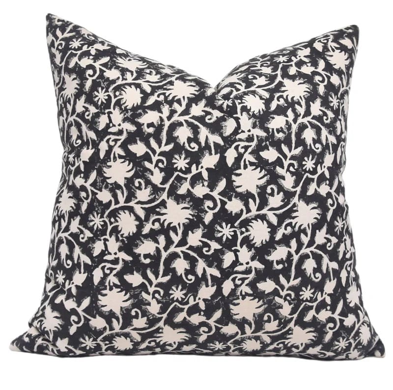 Decorative pillow with black and white floral pattern on a white background