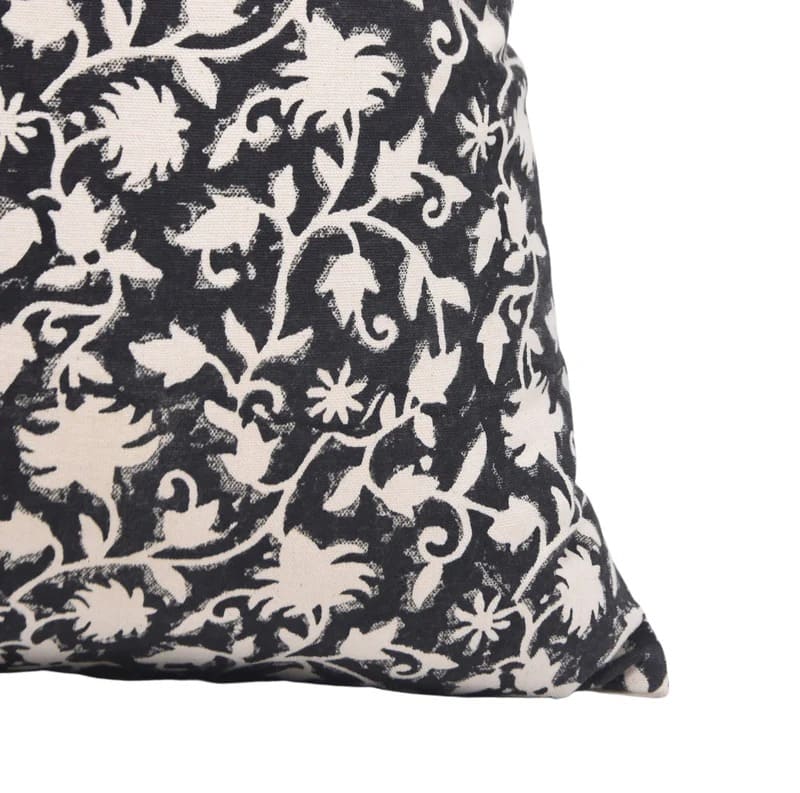 Decorative pillow with black and white floral pattern on a plain background