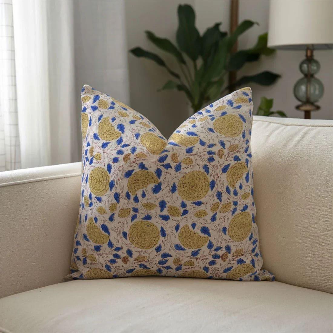 Decorative pillow with yellow and blue pattern on a beige sofa