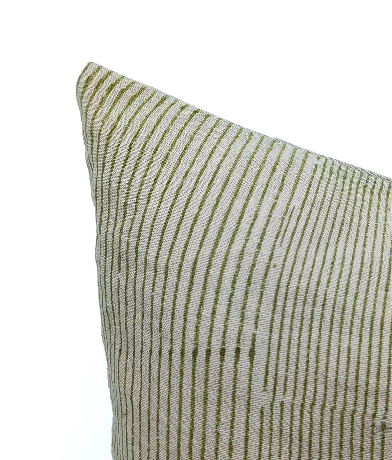 Textured green and white striped pillow on a white background