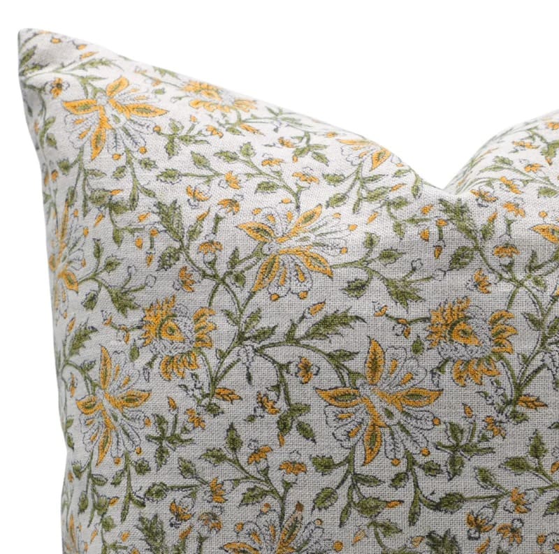 Floral patterned pillow with yellow and green flowers on a light 
