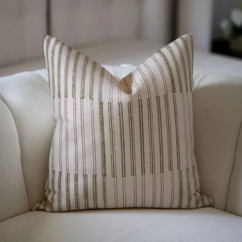 Striped pillow on a beige sofa with a blurred background