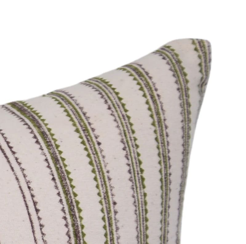Decorative pillow with green and brown striped pattern on a white background