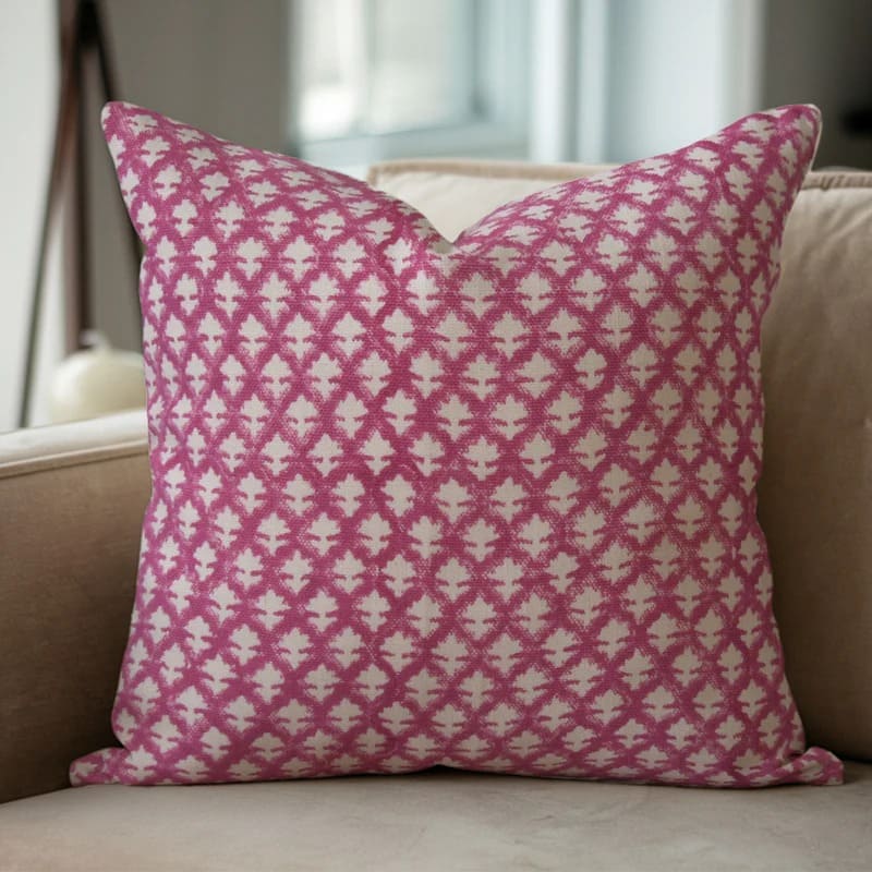 Pink and white patterned pillow on a beige sofa