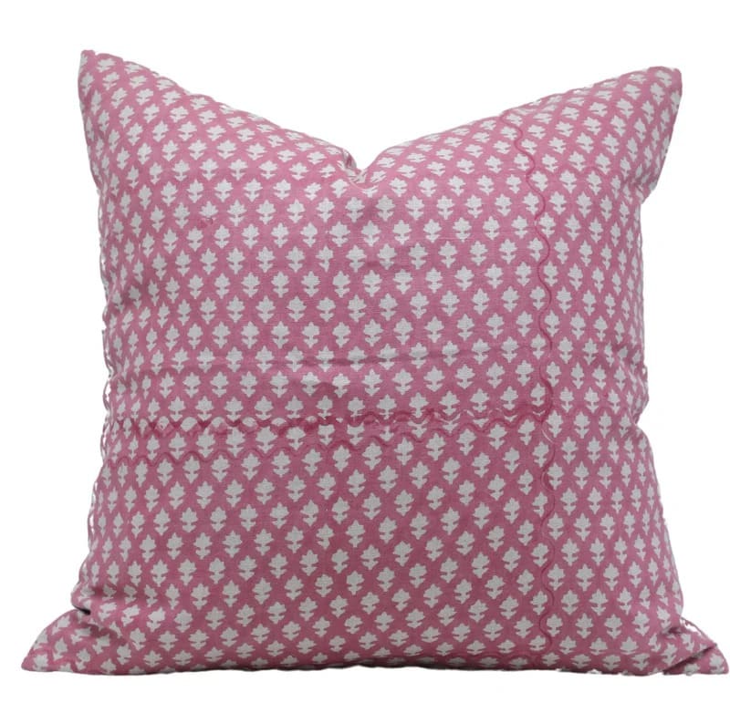 Pink pillow with white geometric pattern on a white background


