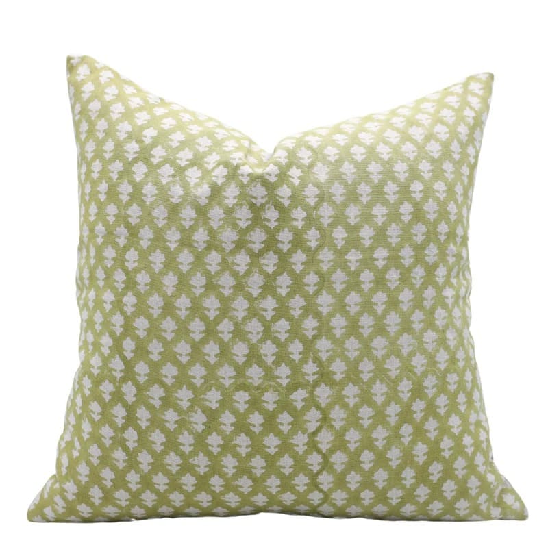 Green pillow with white floral pattern on a white background