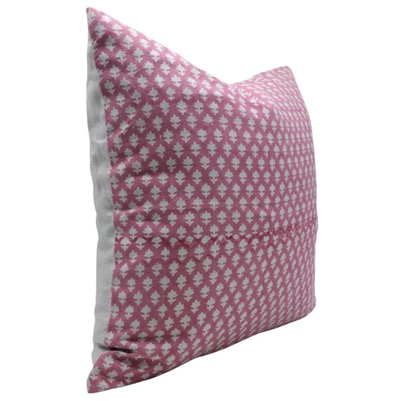 Pink pillow with white geometric pattern on a white background