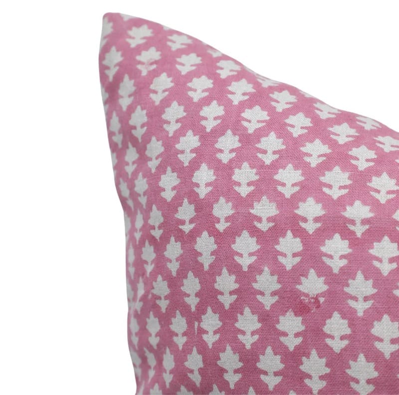 Pink pillow with white geometric pattern on a white background

