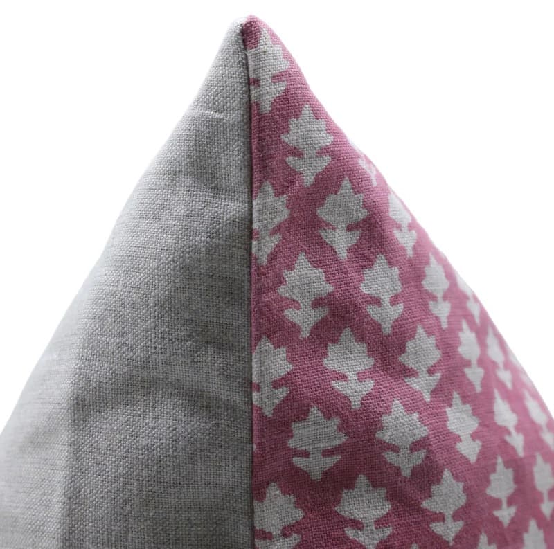 Close-up of a pillow with gray and pink geometric pattern on a white background

