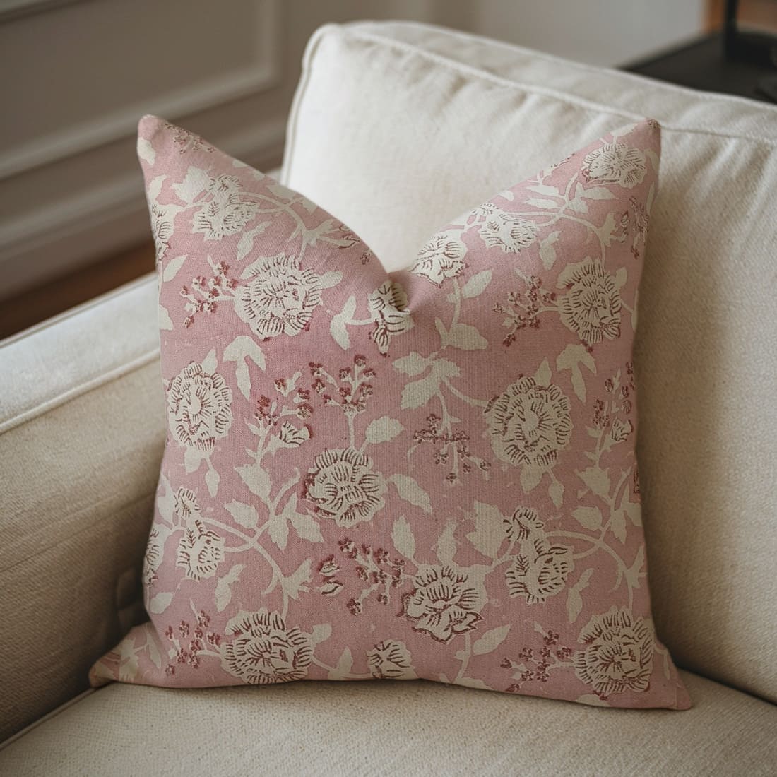 Pink floral pillow on a beige sofa