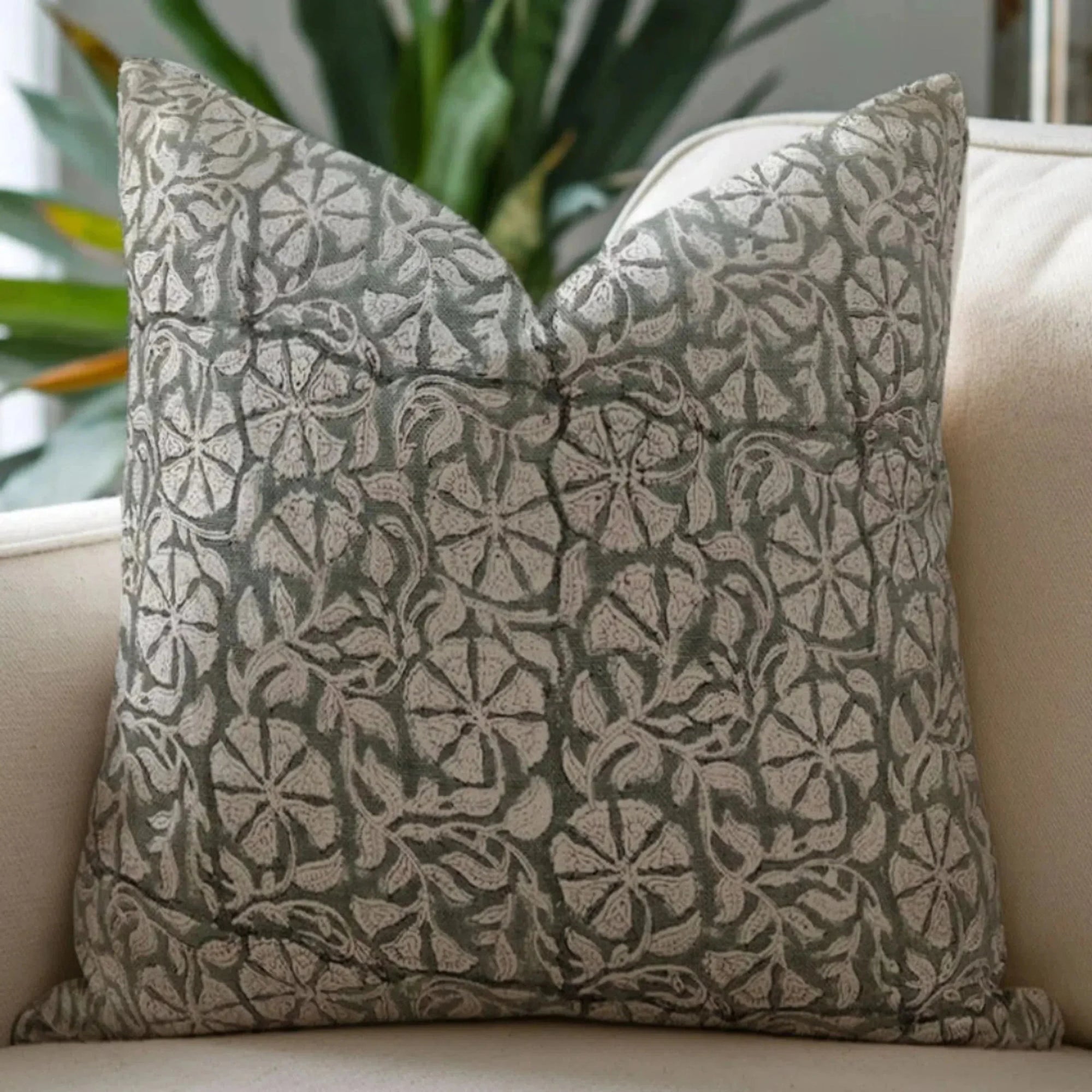 Decorative pillow with a floral pattern on a beige couch