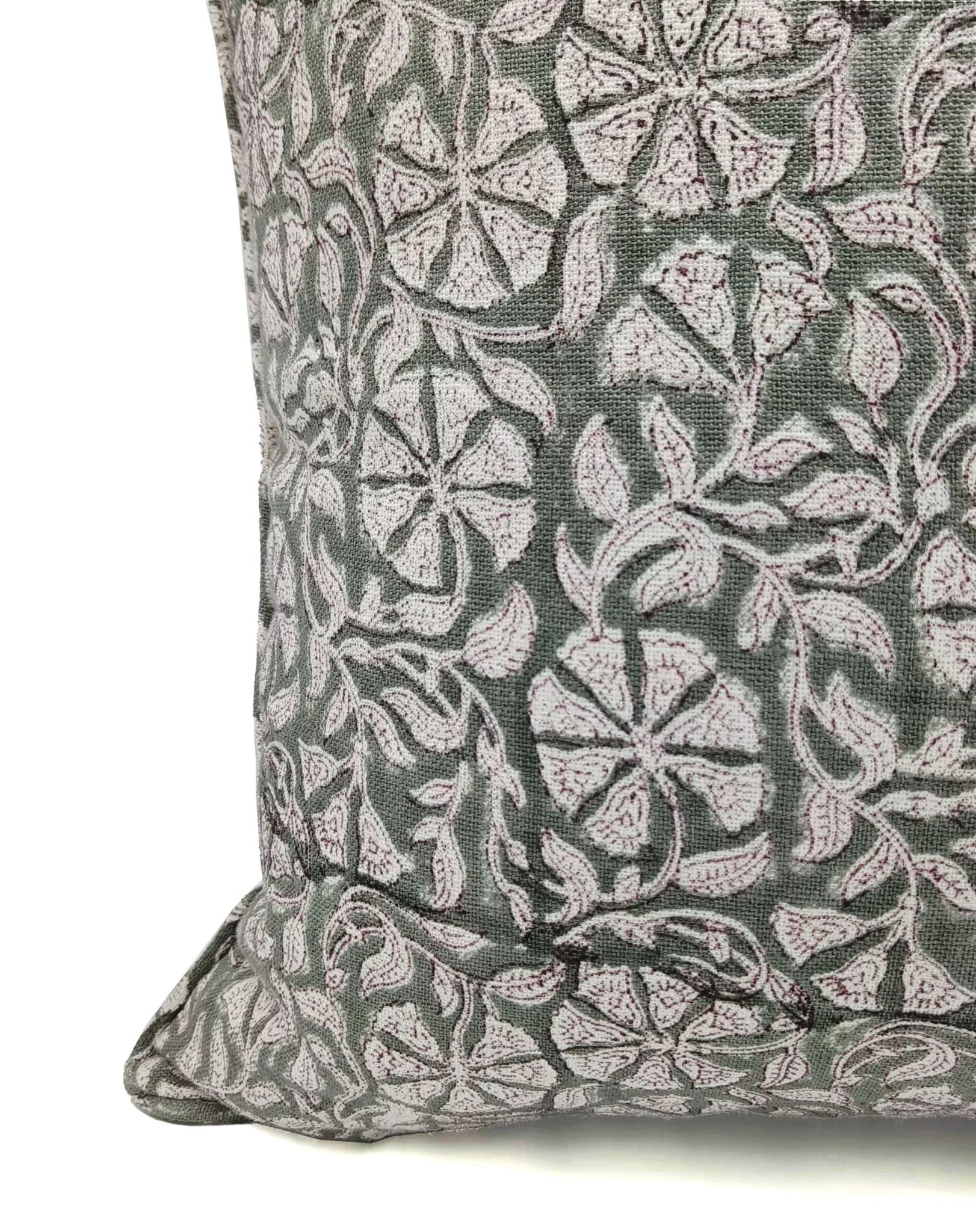Gray pillow with white floral pattern on a white background