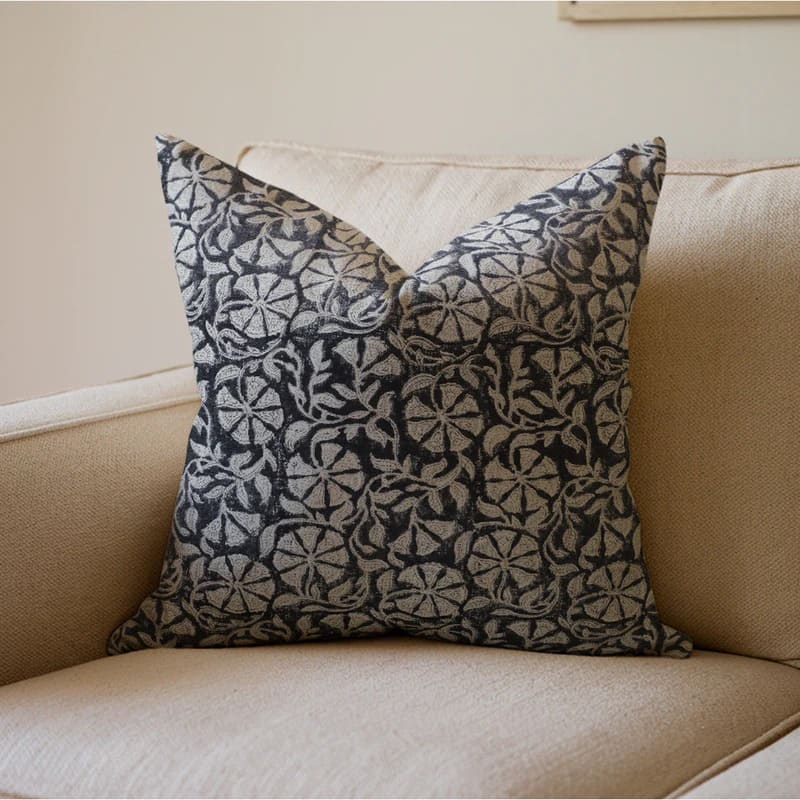 Decorative pillow with black and white pattern on a beige couch

