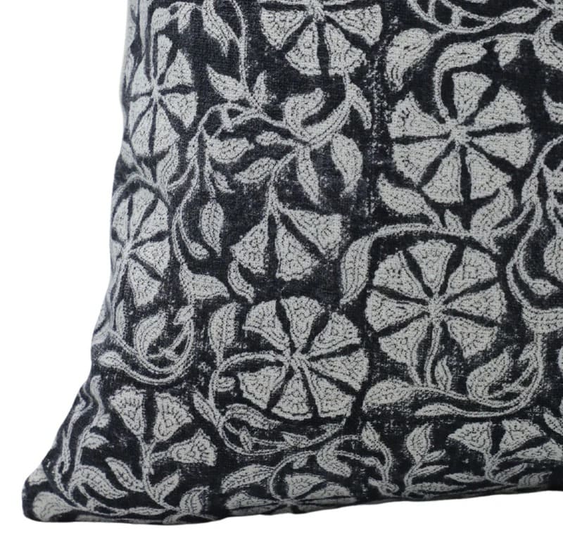 Decorative pillow with black and white floral pattern on a plain background

