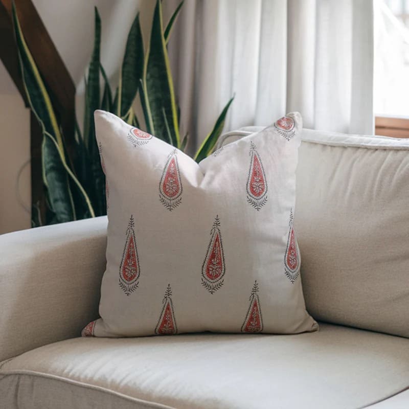 Decorative pillows with a geometric pattern on a beige sofa.

