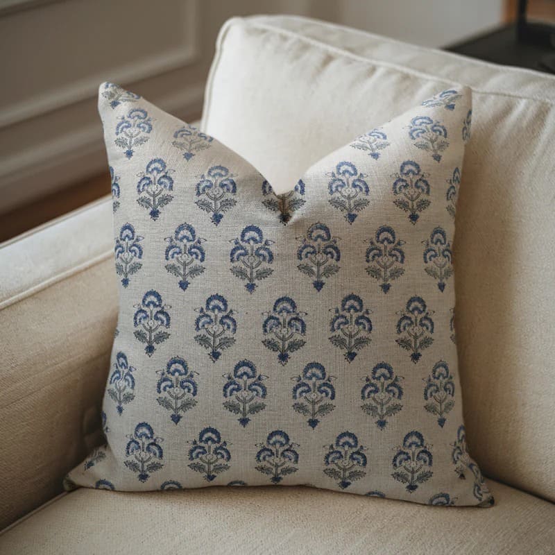 Decorative pillow with blue floral pattern on a beige sofa

