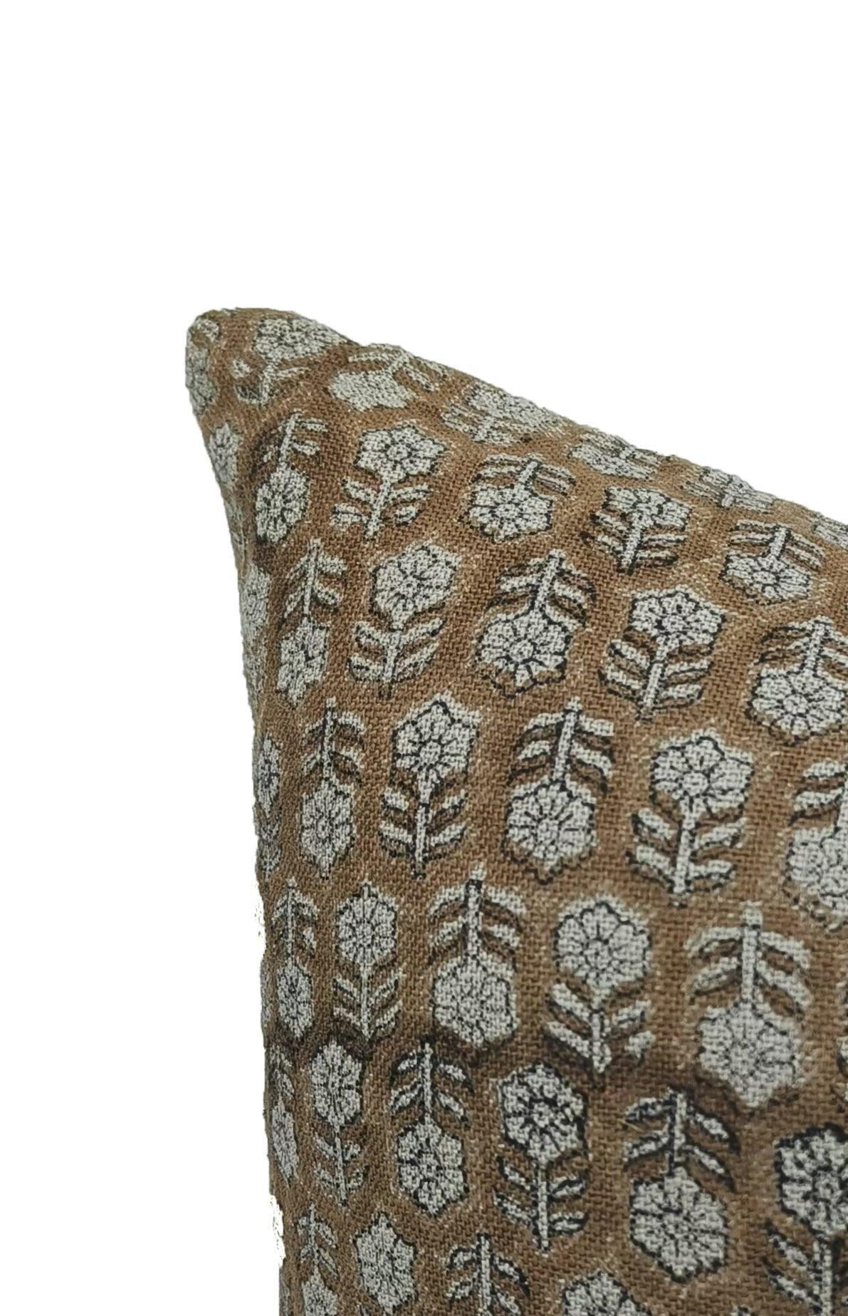 Decorative pillow with floral pattern on a brown fabric