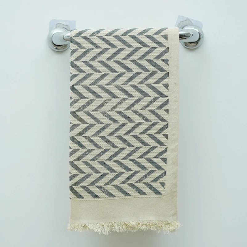 Green hand towel folded on bathroom ledge