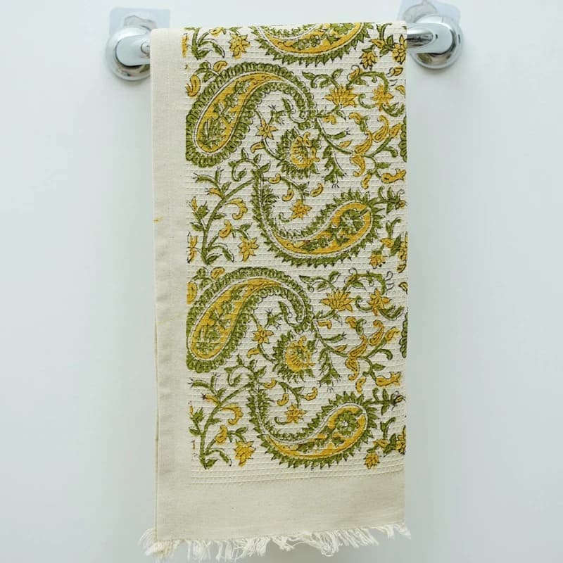 Green towel rolled neatly for guest bathroom