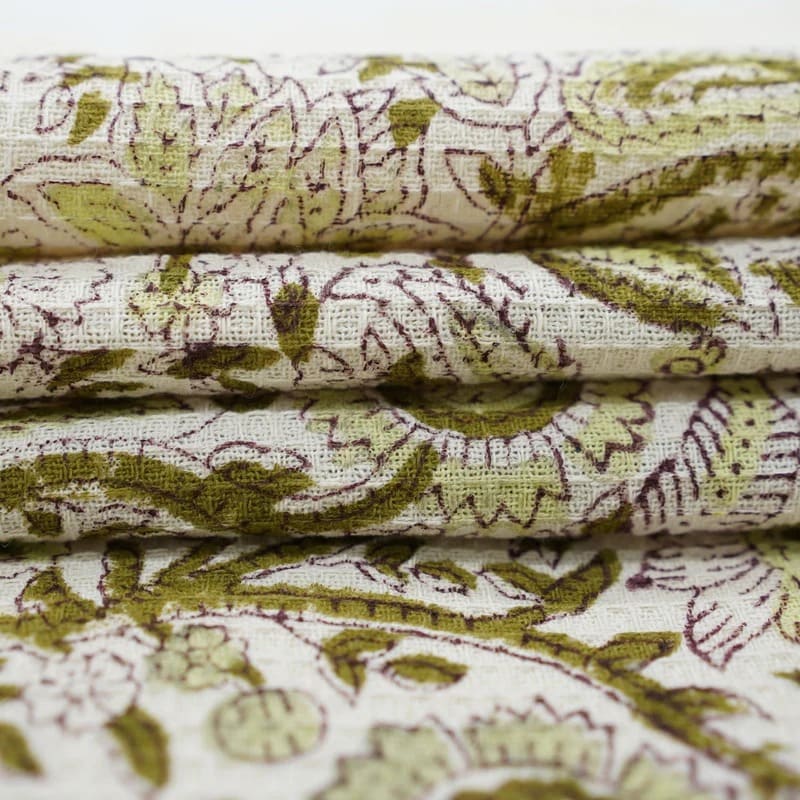 Green patterned towel draped over bathtub