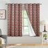 Red and green patterned curtains hanging in a room with a window.