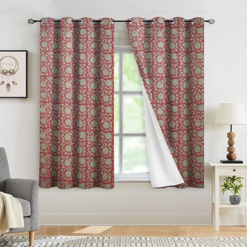 Red and green patterned curtains hanging in a room with a window.