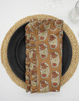 Beige elephant block print frill napkin on a cozy dining table.