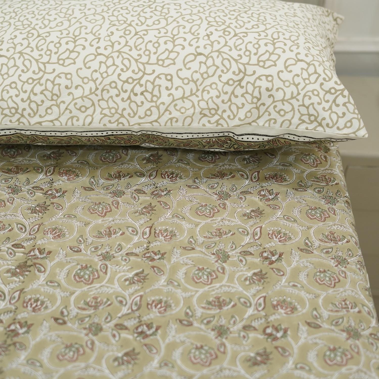 Floral patternedbed sheet with a matching pillow on a neutral background