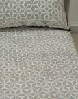 Bedspread with geometric pattern on a bed in a room setting