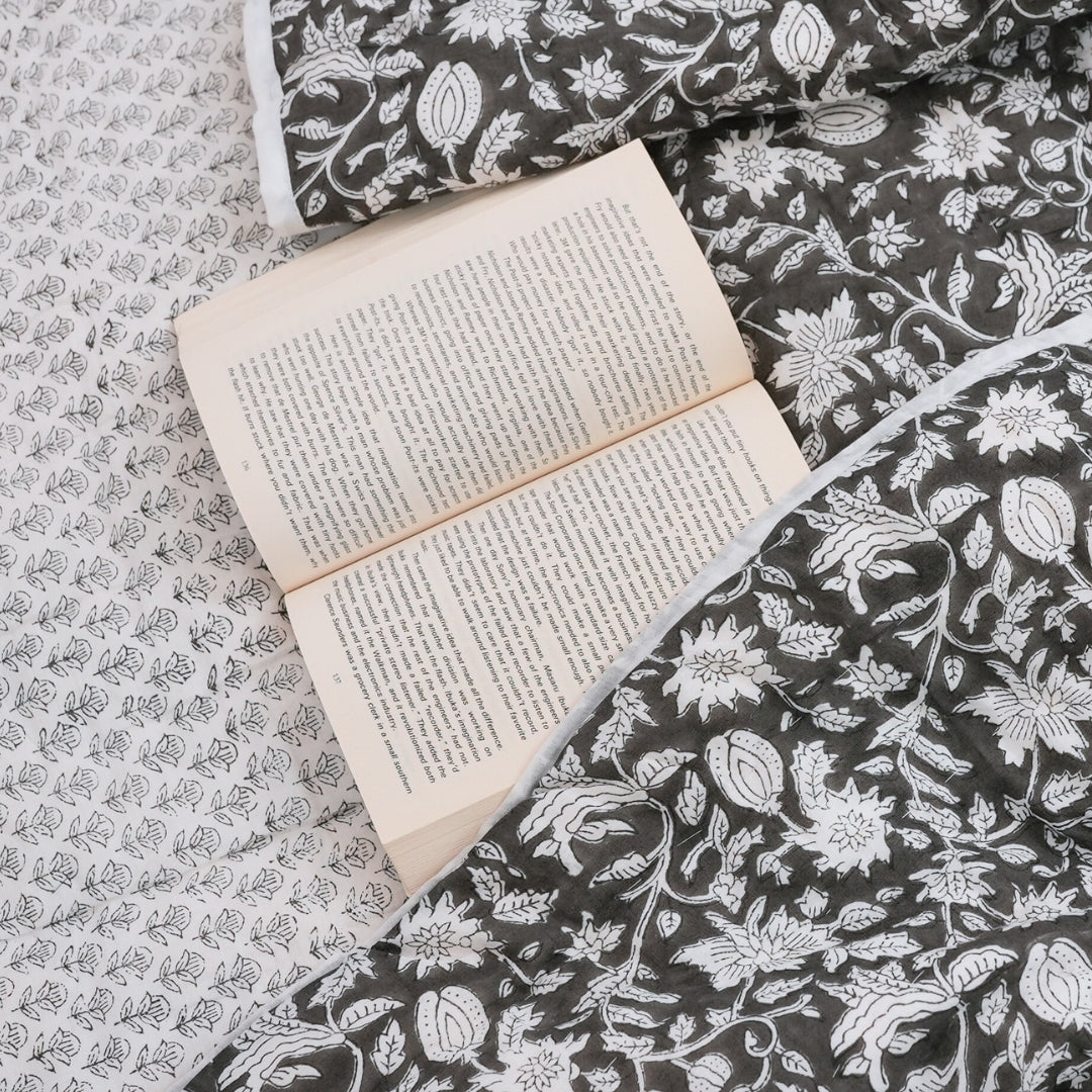 block printed quilt on bed with book
